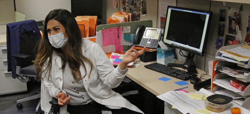 A health investigator sits at her desk at the Salt Lake County health department.