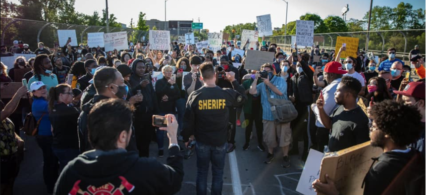 Sheriff Chris Swanson of Genesee County, Michigan, walks with protesters in Flint Township on May 30.