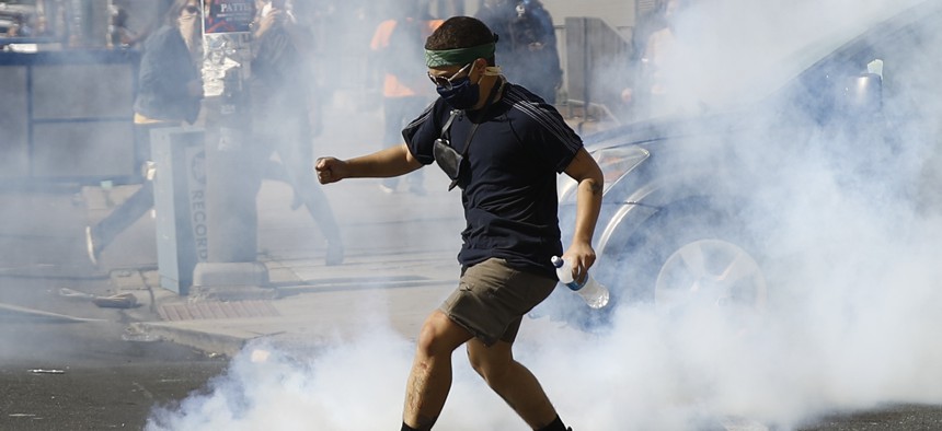 A protester kicks a tear gas canister fired by police as protests continue on May 31, 2020, in Philadelphia over the death of George Floyd. Floyd died May 25 after he was pinned at the neck by a Minneapolis police officer. 
