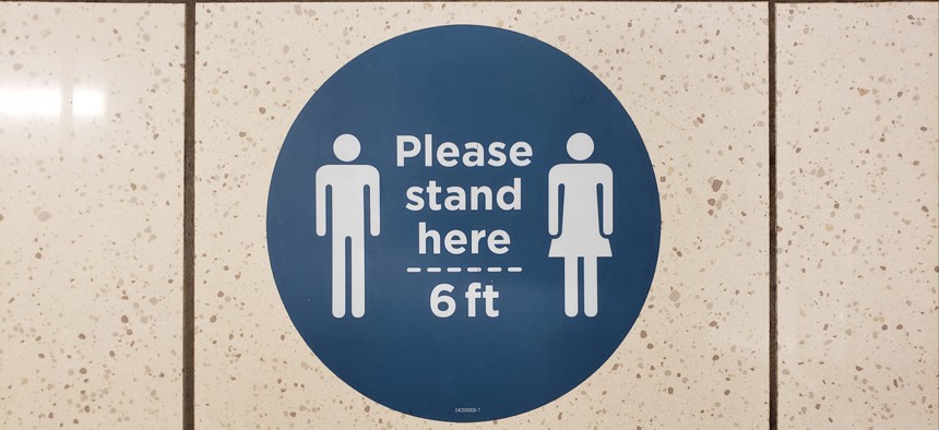 Some reopened businesses have put signs on the floor reminding customers to socially distance.