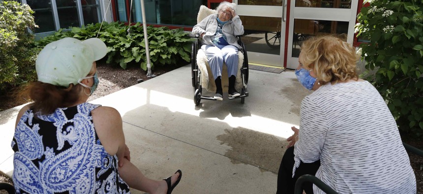 A resident and visitors at the Hebrew Rehabilitation Center, on June 10, 2020, in Boston.