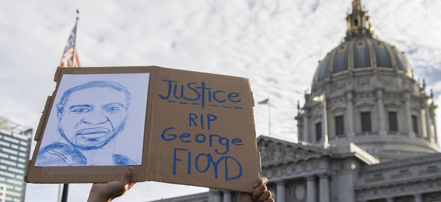 A sign is held up outside of San Francisco City Hall during a protest over the death of George Floyd in police custody.