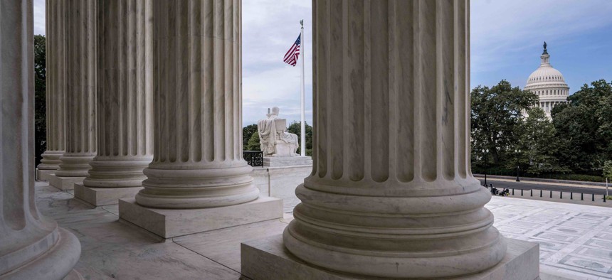 he columns of the Supreme Court are seen with the Capitol at right, in Washington, early Monday, June 15, 2020. 