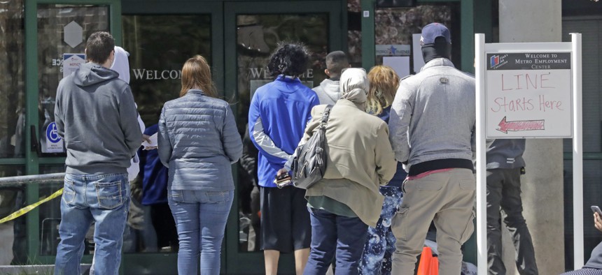 In this April 2020, file photo, people line up outside the Utah Department of Workforce Services in Salt Lake City.