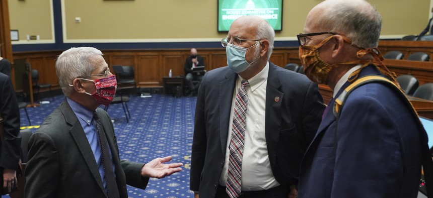Director of the National Institute of Allergy and Infectious Diseases Dr. Anthony Fauci, left, speaks with Dr. Robert Redfield, director of the Centers for Disease Control and Prevention, center, after testifying before a House committee.