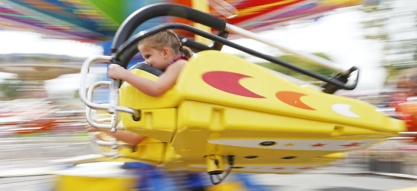 A young girl hangs on as she enjoys a ride at the Minnesota State Fair Tuesday, Aug. 30, 2016, in Falcon Heights, Minn.