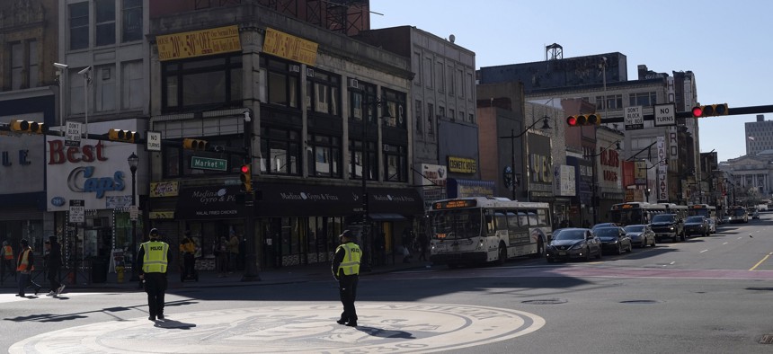 Newark police officers, encouraging people to practice social distancing, patrol an intersection in Newark, N.J., Thursday, March 26, 2020.