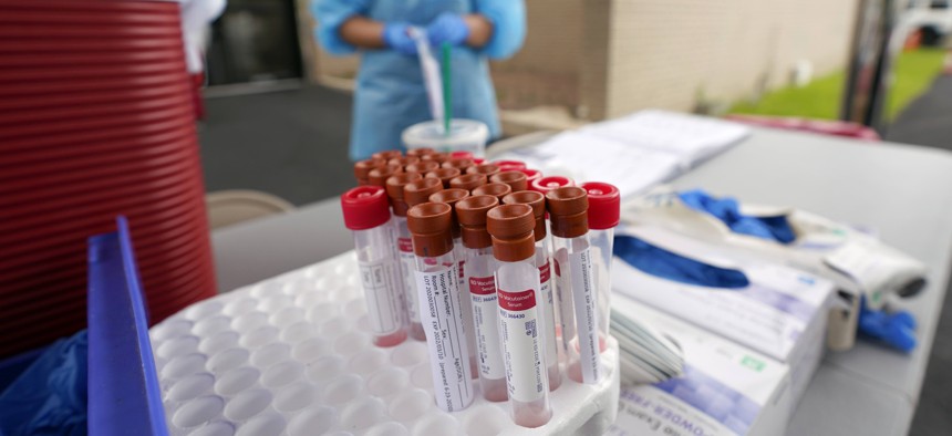 Test kits sit on a table as healthcare professional Kenzie Anderson prepares to take a sample at a United Memorial Medical Center COVID-19 testing site Friday, June 26, 2020, in Houston. The number of COVID-19 cases continues to rise across the state. 