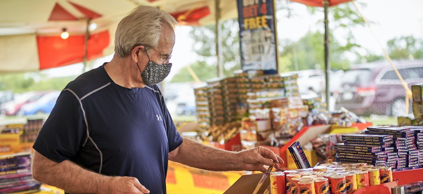A man wears a face mask as he shops for fireworks at Wild Willy's Fireworks tent in Omaha, Neb., Monday, June 29, 2020, ahead of the Fourth of July holiday. (AP Photo/Nati Harnik)