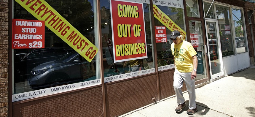 A man walks past a retail store that is going out of business due to the coronavirus pandemic in Winnetka, Ill. on June 23, 2020. 
