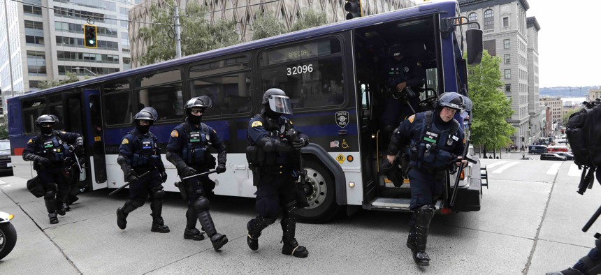 Washington State Police troopers walk off of a bus in front of Seattle City Hall as they prepare for demonstrators to arrive Wednesday, June 3, 2020, in Seattle.