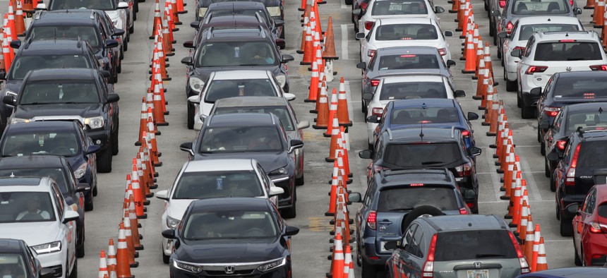 Lines of cars wait at a drive-through coronavirus testing site on July 5, 2020, outside Hard Rock Stadium in Miami Gardens, Fla.