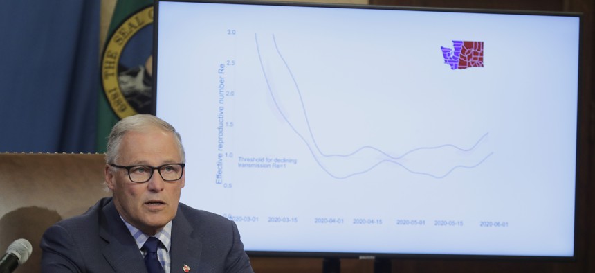 Washington Gov. Jay Inslee speaks at a news conference showing a chart of the "reproductive number" of each case of the coronavirus in the eastern and western parts of the state. Data and evidence have become instrumental in governors decision-making.