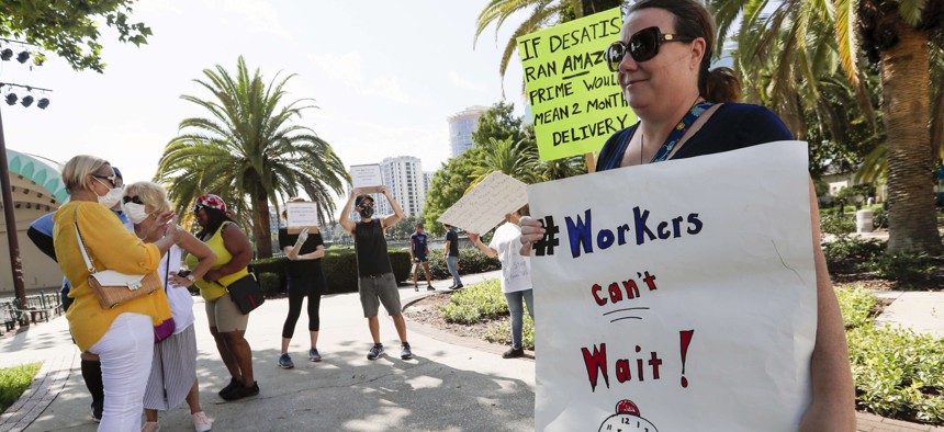 A small group of demonstrators gathers at Lake Eola Park to protest the Florida unemployment benefits system, Wednesday, June 10, 2020, in Orlando, Fla.