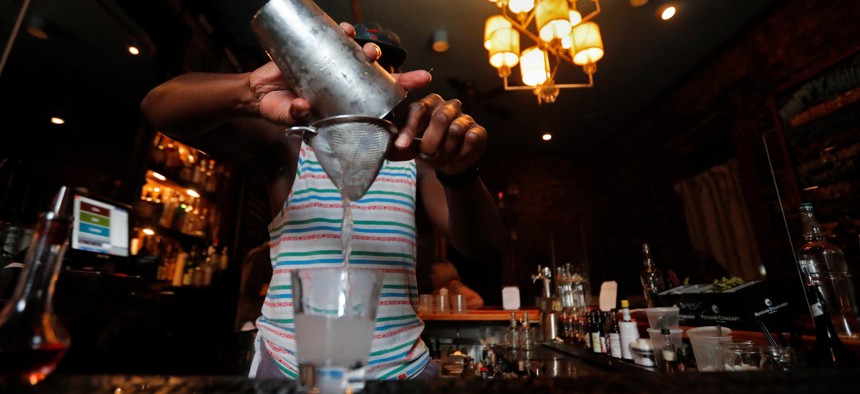 A bartender makes cocktails inside Bar Tonique in New Orleans on July 9, 2020. Two days later, Louisiana Gov. John Bel Edwards ordered all bars to close.