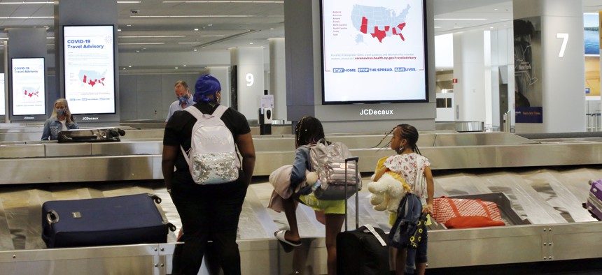 Travelers arriving from Atlanta await their luggage in the baggage claim area of Terminal B at LaGuardia Airport, Thursday, June 25, 2020, in New York. 