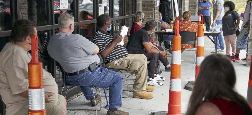 Job seekers exercise social distancing as they wait to be called into the Heartland Workforce Solutions office in Omaha, Neb., Wednesday, July 15, 2020. 