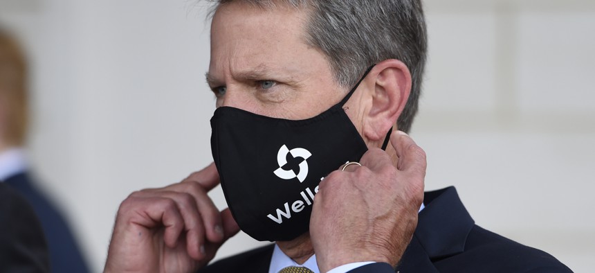 Georgia Gov. Brian Kemp adjusts his mask prior to a bill signing at Wellstar Kennestone Hospital where the hospital opened a new Emergency Room space, Thursday, July 16, 2020, in Marietta, Ga.