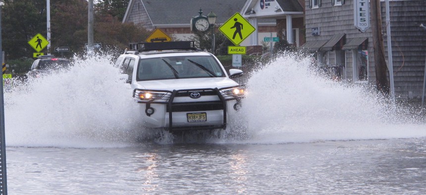 A car drives through a flooded road in Bay Head, N.J. on Friday Oct. 11, 2019, after a combination of high tides and strong winds caused minor to moderate flooding along parts of the shore.
