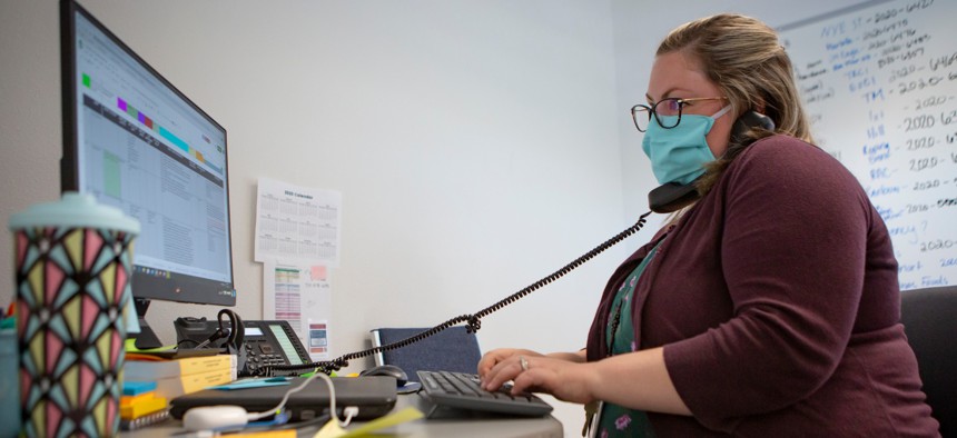 Heather Griggs, operations chief of the Umatilla County Public Health Department COVID-19 contact tracing center in Pendleton, Ore., checks in with public health staff in neighboring Morrow County.