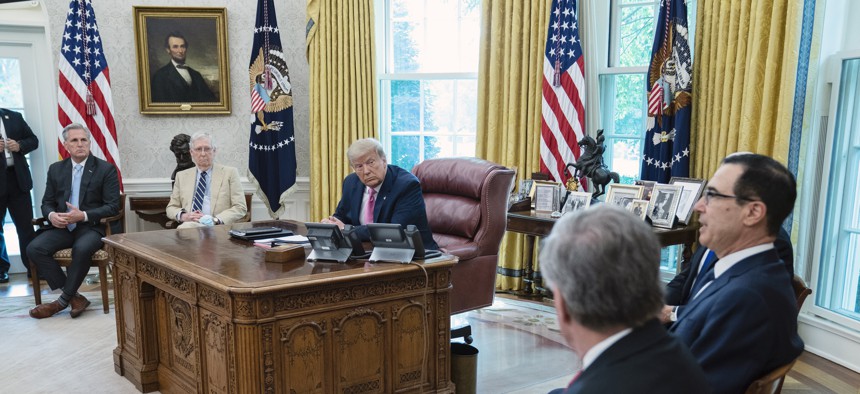 House Minority Leader Kevin McCarthy of Calif., left, speaks during a meeting with Senate Majority Leader Mitch McConnell of Ky., center, and President Donald Trump in the Oval Office of the White House, Monday, July 20, 2020, in Washington. 