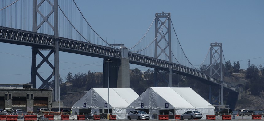 A Covid-19 testing site sits in front of the San Francisco-Oakland Bay Bridge during the coronavirus outbreak in San Francisco, Saturday, July 11, 2020. (AP Photo/Jeff Chiu)