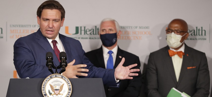 Florida Gov. Ron DeSantis, left, speaks during a news conference as Vice President Mike Pence and Henri Ford, right, dean of the University of Miami Leonard M. Miller School of Medicine.
