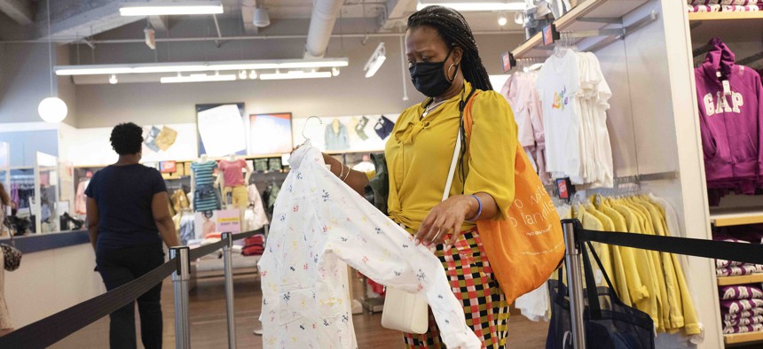 In this June 30, 2020, photo, a woman shops for clothing in a Gap store during the coronavirus pandemic, in New York. 