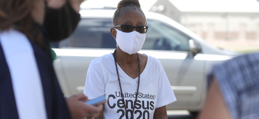 Amid concerns of the spread of COVID-19, census worker Jennifer Pope wears a mask and sits by ready to help at a U.S. Census walk-up counting site set up for Hunt County in Greenville, Texas, Friday, July 31, 2020. 
