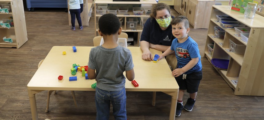 Teachers wear masks as they work with kids at the Frederickson KinderCare daycare center, in Tacoma, Wash. 