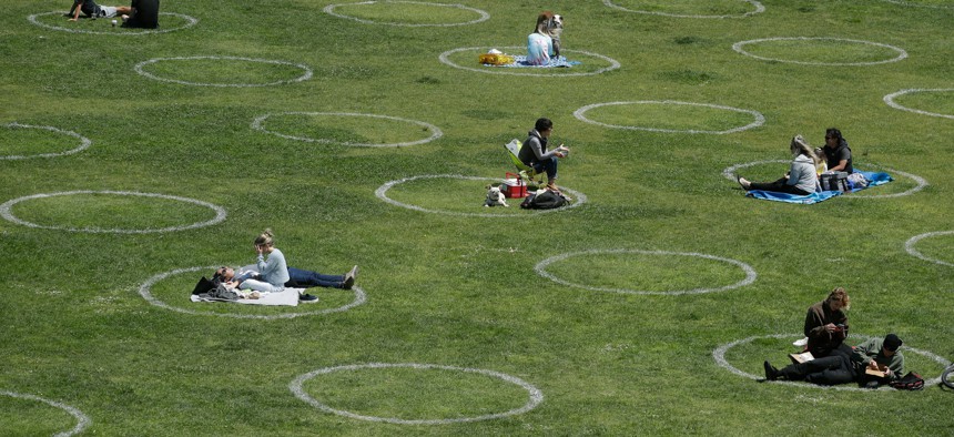 Visitors set up inside circles designed to help prevent the spread of the coronavirus by encouraging social distancing, at Dolores Park in San Francisco on June 28, 2020. 