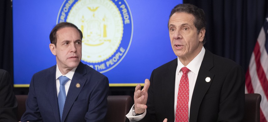 Dr. Howard Zucker, left, Commissioner of the New York State Department of Health, listens to Gov. Andrew Cuomo in March. Local officials have questioned whether New York's COVID statistics mask the number of nursing home residents who died.