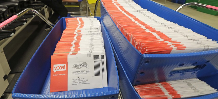 In this Aug. 5, 2020, file photo, vote-by-mail ballots are shown in sorting trays at the King County Elections headquarters in Renton, Wash., south of Seattle. 