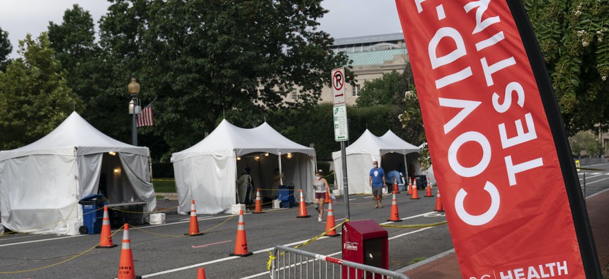 Members with the Washington, D.C. Dept. of Health administer Covid-19 tests on F Street on Aug. 14, 2020. This location tests approximately 450-500 people per week and has been open since June 1. (AP Photo/Alex Brandon)