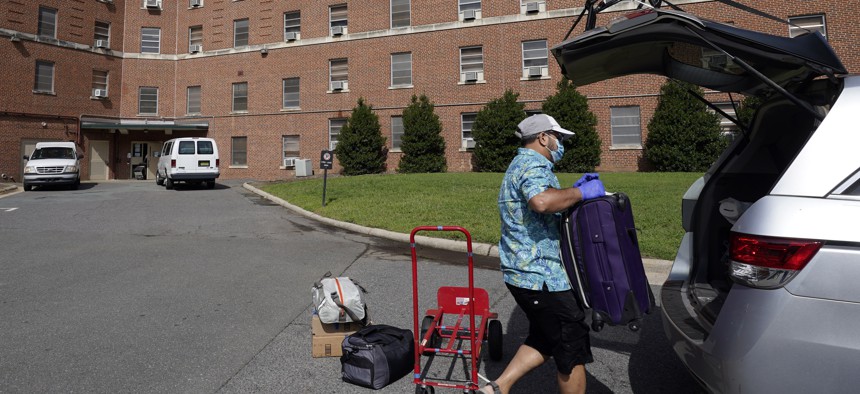 A parent packs a student's belongings at Ehringhaus dormitory following a cluster of COVID-19 cases on campus at the University of North Carolina in Chapel Hill, N.C., Tuesday, Aug. 18, 2020.