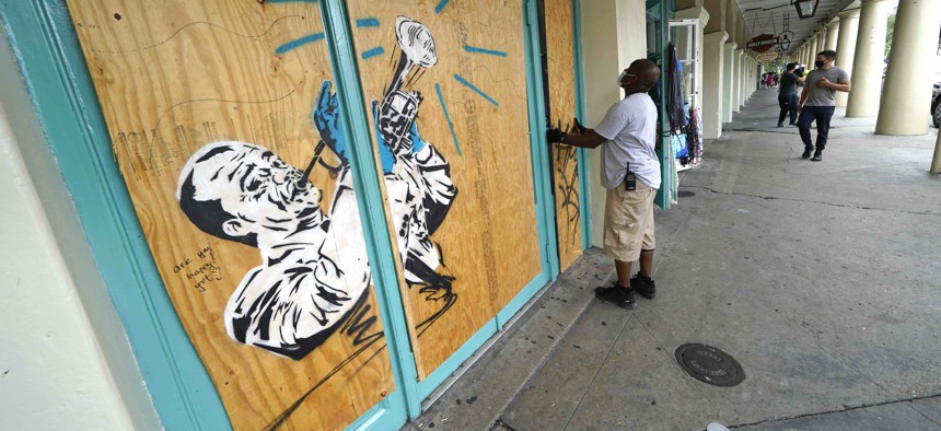 Workers board up shops in the French Quarter of New Orleans, Sunday, Aug. 23, 2020, in advance of Hurricane Marco, expected to make landfall on the Southern Louisiana coast.