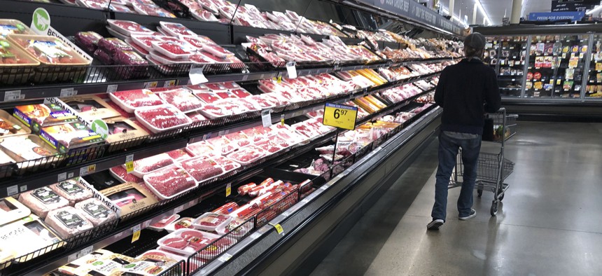 A shopper pushes his cart past a display of packaged meat in a grocery store Sunday, May 10, 2020, in southeast Denver.