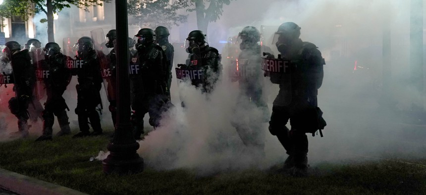 Police clear a park during clashes with protesters outside the Kenosha County Courthouse late Tuesday, Aug. 25, 2020, in Kenosha, Wis., during demonstrations over the Sunday shooting of Jacob Blake.