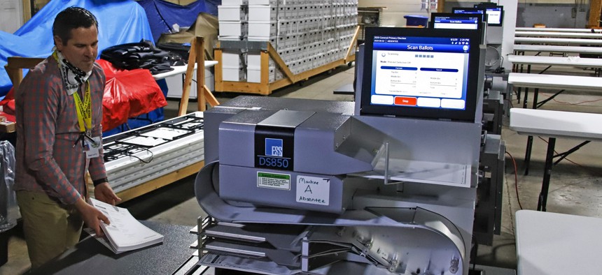 Allegheny County Election Division Deputy Manager Chet Harhut demonstrates a mail-in and absentee ballot counting machine at the Elections warehouse in Pittsburgh on June 1, 2020. 