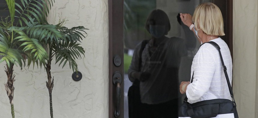 A census taker knocks on the door of a residence on Aug. 11, 2020, in Winter Park, Fla. 