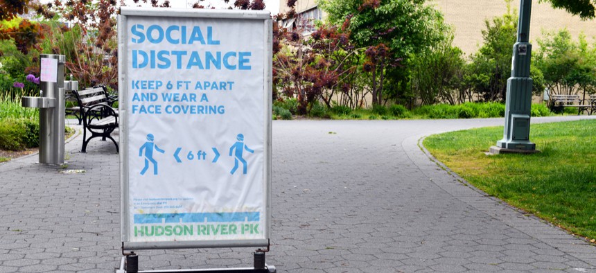 Signs installed by the New York Public Health Department remind people to social distance.