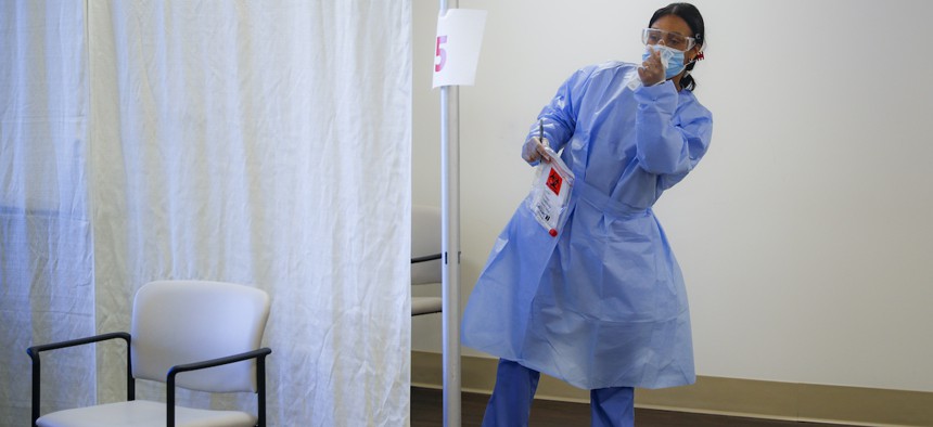 A nurse gestures for a patient as on-campus staff working on the grounds of the Hebrew Home at Riverdale are tested for COVID-19 by nasal swab before they can begin their shifts, Friday, June 12, 2020, in the Bronx borough of New York.