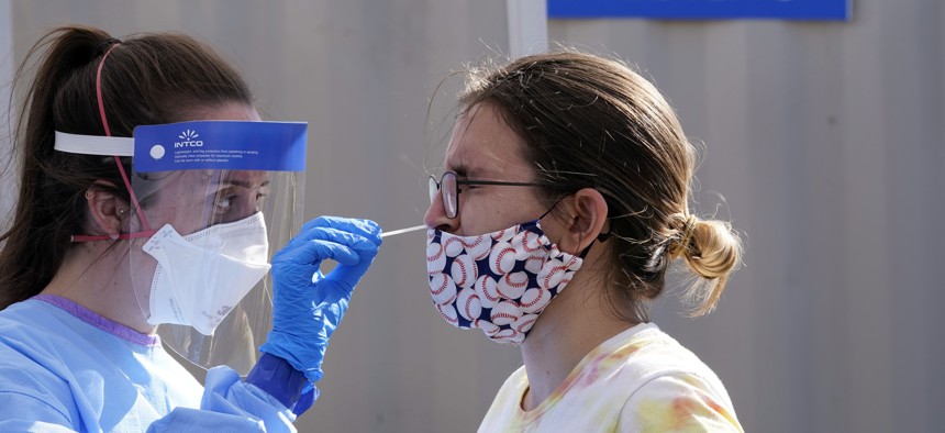 A woman is tested for Covid-19 at a walk-up testing site in Seattle. Auditors from nearly a dozen states are planning to review how pandemic data is being tracked.