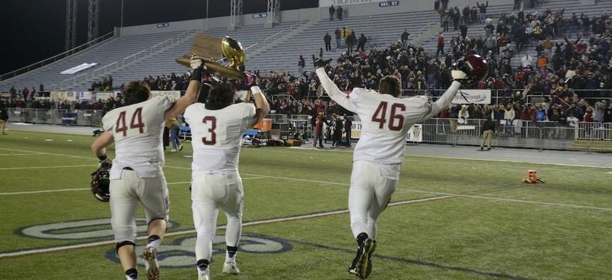 St. Joseph Prep's players run with the championship trophy to fans after a championship football game against Pine-Richland in Hershey, Pa. on Saturday, Dec. 13, 2014. St Joseph won 49-41. (AP Photo/Ralph Wilson)