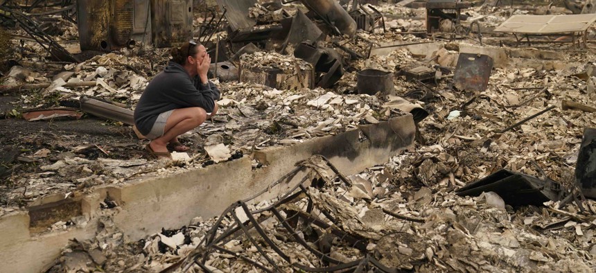 A woman cries as she visits her home destroyed by the Almeda Fire, Friday, Sept. 11, 2020, in Talent, Ore.