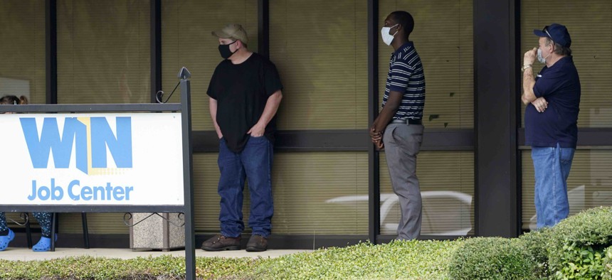 In this Aug. 31, 2020 photo, clients line up outside the Mississippi Department of Employment Security WIN Job Center in Pearl, Miss.