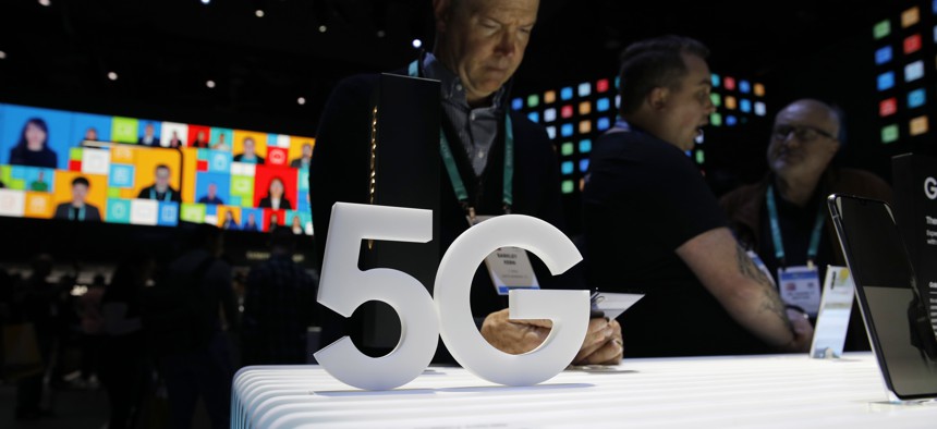 People loook at 5G phones at the Samsung booth during the CES tech show, Tuesday, Jan. 7, 2020, in Las Vegas.