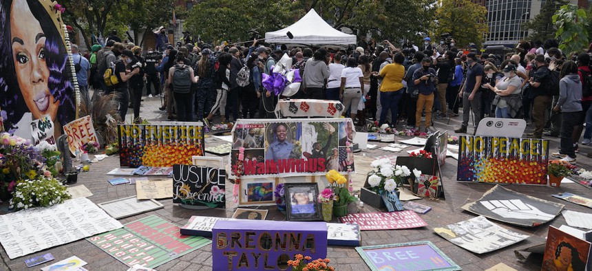People gather in Louisville awaiting word on charges against police officers, Wednesday, Sept. 23, 2020. A grand jury indicted one officer on criminal charges six months after police killed 26-year-old Breonna Taylor in her apartment.