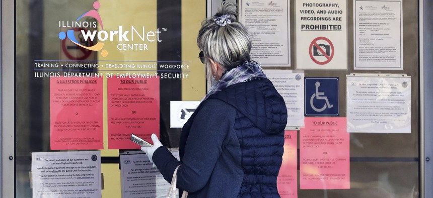 A woman checks job application information in front of IDES (Illinois Department of Employment Security)/WorkNet center in Arlington Heights, Ill. 