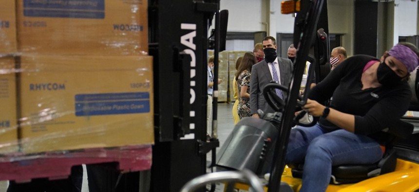 Oklahoma Gov. Kevin Stitt, rear, watches as a forklift operator loads boxes of PPE for Edmond Public Schools at the Central Oklahoma PPE distribution warehouse on Aug. 18, 2020, in Oklahoma City. 